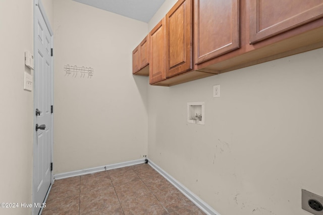 clothes washing area with cabinets, hookup for a washing machine, light tile patterned floors, and hookup for an electric dryer