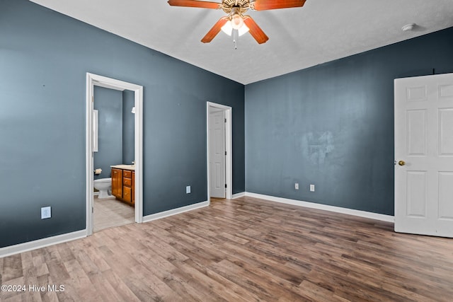 unfurnished bedroom featuring a textured ceiling, ensuite bathroom, light hardwood / wood-style flooring, and ceiling fan