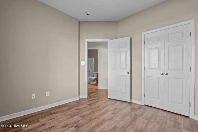 unfurnished bedroom with hardwood / wood-style floors and a closet