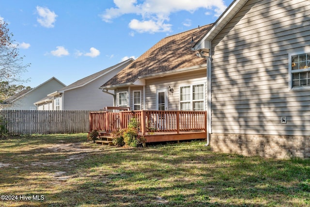 rear view of property featuring a yard and a deck