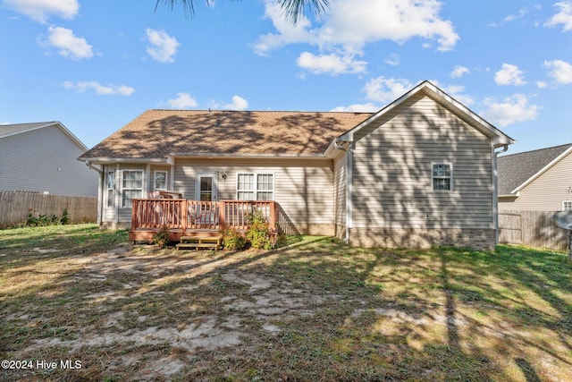 rear view of property featuring a yard and a wooden deck