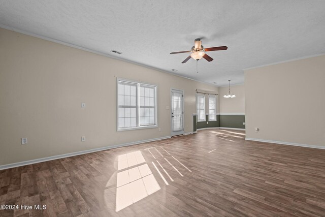 unfurnished living room with ceiling fan with notable chandelier, ornamental molding, a textured ceiling, and hardwood / wood-style flooring