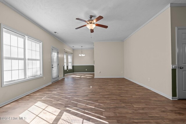 unfurnished living room with a textured ceiling, dark hardwood / wood-style floors, crown molding, and ceiling fan with notable chandelier