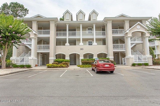 view of building exterior with uncovered parking