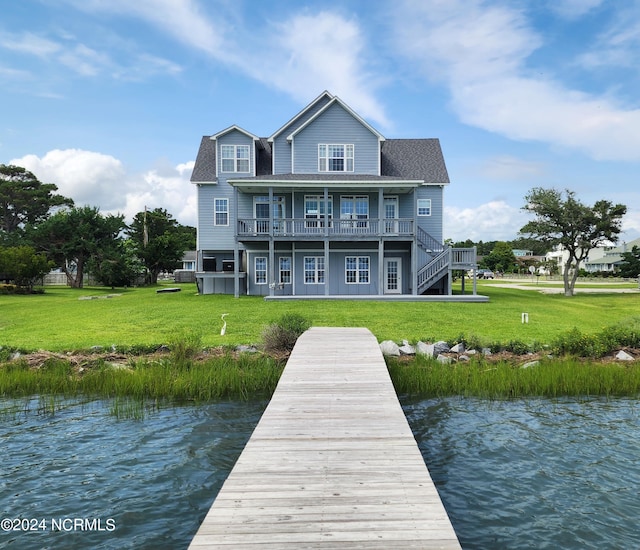 rear view of house with a yard and a water view