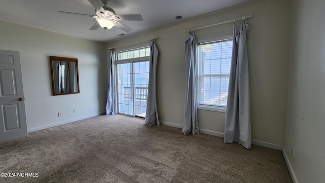 carpeted empty room featuring ceiling fan