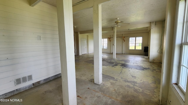 interior space featuring ceiling fan and wood walls