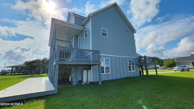 back of property featuring a lawn and a deck