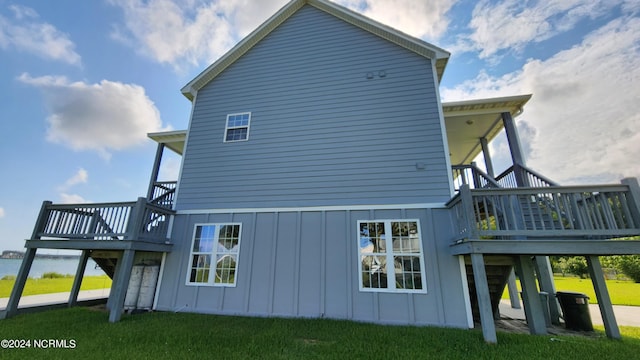 rear view of house with a deck and a lawn