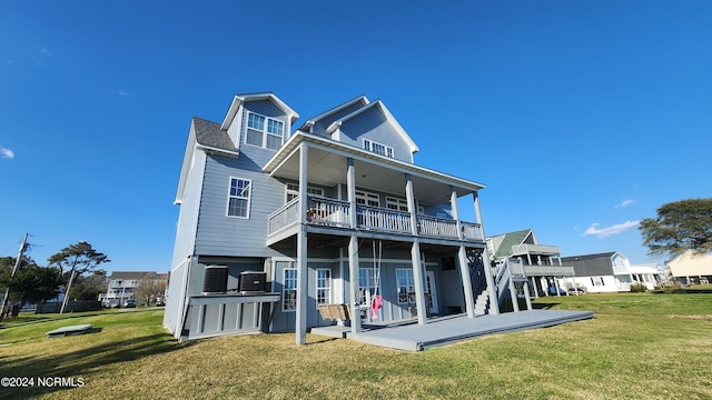 rear view of property featuring a lawn, a patio area, and a balcony