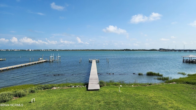 view of dock featuring a lawn and a water view