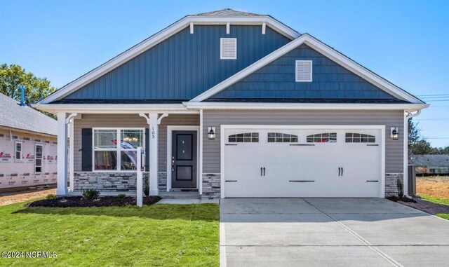 craftsman house with a garage and a front lawn