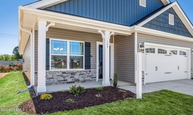 entrance to property featuring covered porch and a lawn