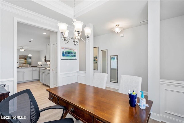 dining space with crown molding, ceiling fan with notable chandelier, and light hardwood / wood-style flooring