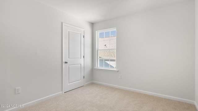 spare room featuring light carpet