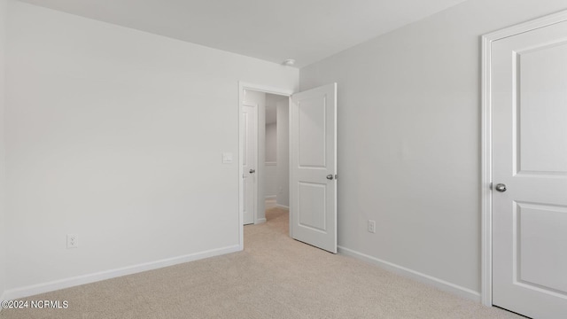 unfurnished bedroom featuring light colored carpet