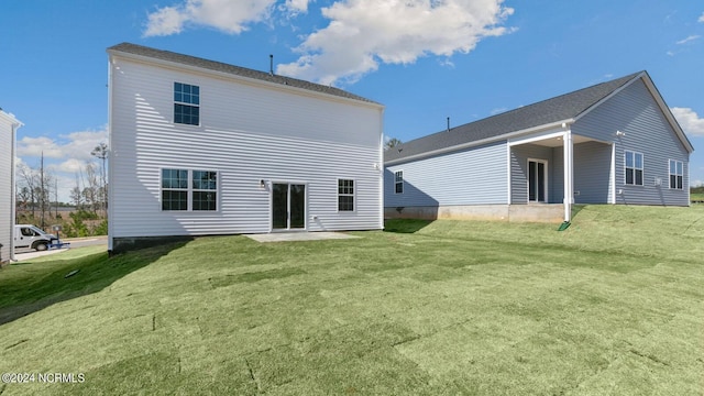 rear view of property with a lawn and a patio area