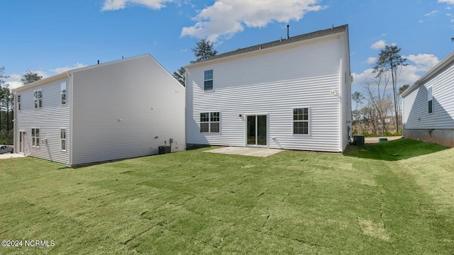 rear view of property featuring a lawn, cooling unit, and a patio area