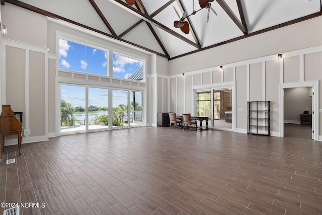 unfurnished living room featuring beam ceiling, ceiling fan, and high vaulted ceiling