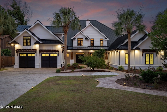 modern inspired farmhouse featuring a lawn and a garage