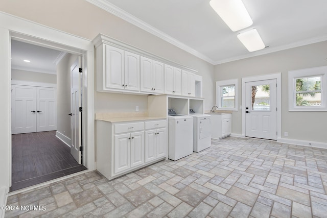 washroom featuring washer and clothes dryer, cabinets, ornamental molding, and sink