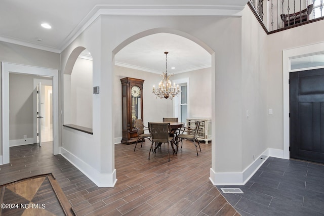 entryway featuring crown molding and a chandelier