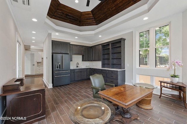 kitchen featuring high end refrigerator, a towering ceiling, dark brown cabinetry, and crown molding