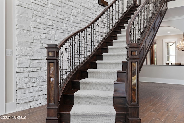 stairs with ornamental molding and a chandelier