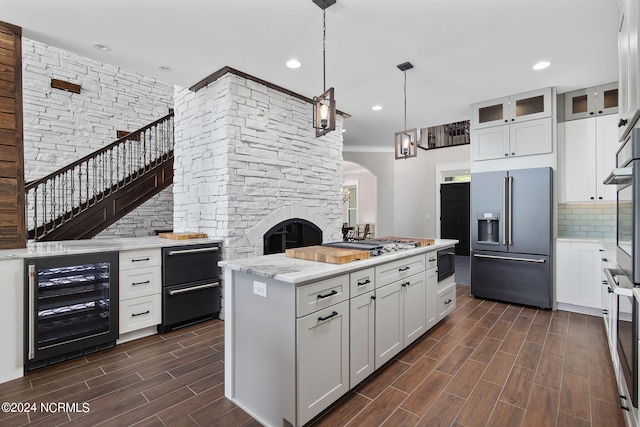 kitchen with wine cooler, white cabinetry, high end fridge, and black microwave