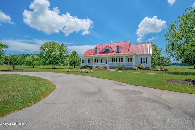 cape cod house with metal roof, aphalt driveway, a porch, and a front yard