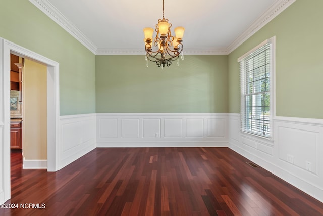 empty room with a notable chandelier, visible vents, ornamental molding, wainscoting, and dark wood finished floors