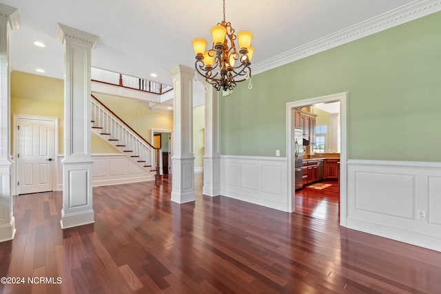 dining area featuring dark hardwood / wood-style floors, ornate columns, ornamental molding, and a chandelier