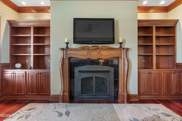 unfurnished living room featuring a fireplace, crown molding, and dark hardwood / wood-style flooring