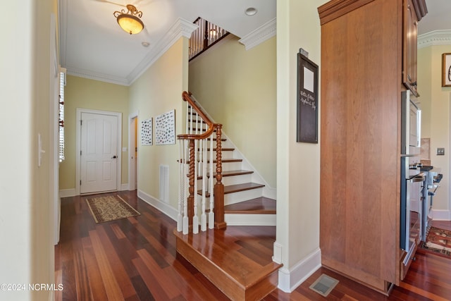 foyer entrance featuring stairs, ornamental molding, wood finished floors, and visible vents