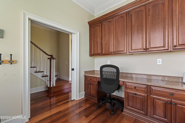 office area with ornamental molding, built in study area, dark wood finished floors, and baseboards