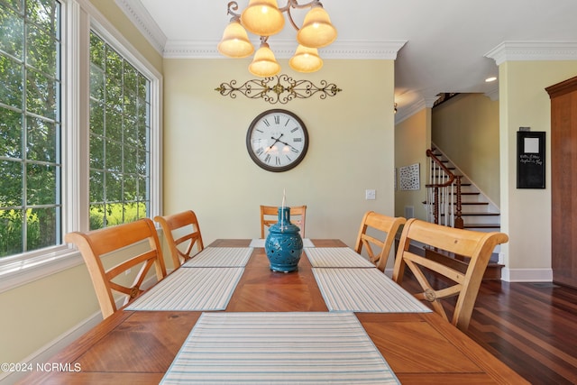 dining space with baseboards, ornamental molding, a chandelier, and wood finished floors