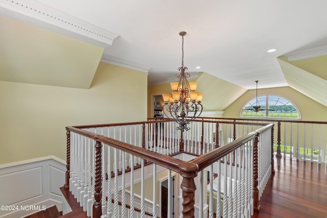 hall with dark wood-type flooring, ornamental molding, lofted ceiling, and a notable chandelier