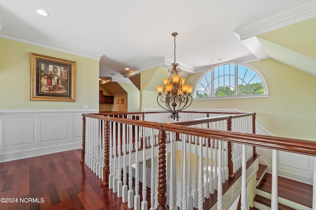 hallway with dark wood-type flooring, vaulted ceiling, a notable chandelier, and crown molding