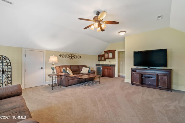 living room with light carpet, beverage cooler, ceiling fan, wet bar, and lofted ceiling