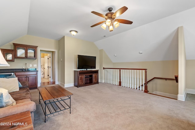 carpeted living room with vaulted ceiling, ceiling fan, and sink