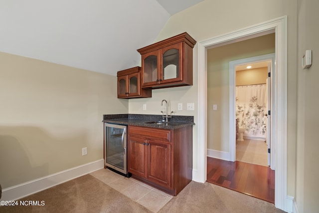 bar with wine cooler, vaulted ceiling, light colored carpet, and a sink