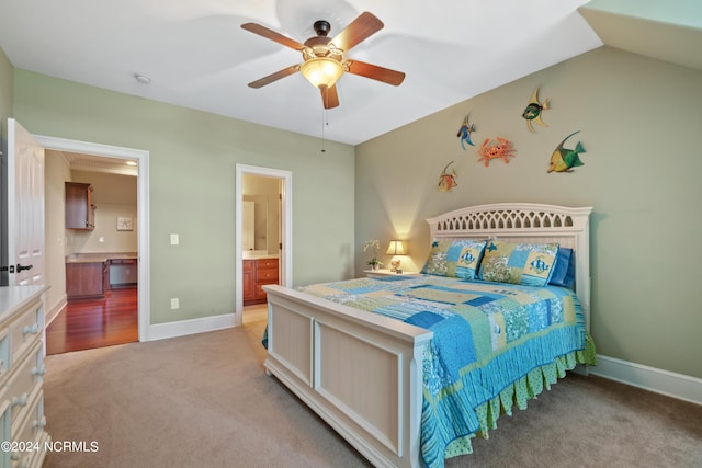 bedroom with light colored carpet, ensuite bathroom, a ceiling fan, vaulted ceiling, and baseboards