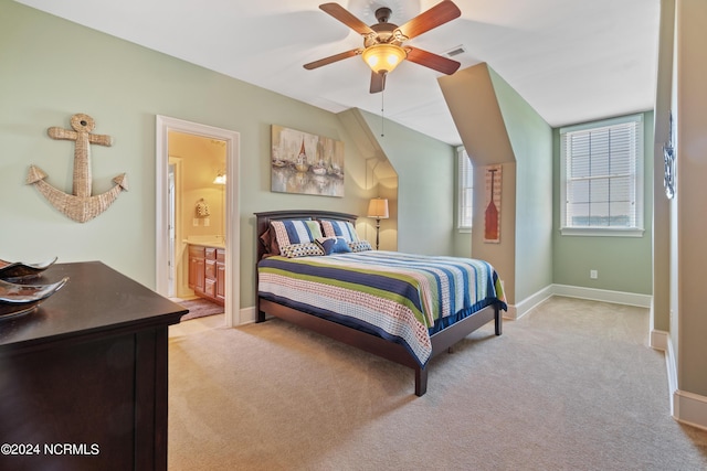 carpeted bedroom with ensuite bath and ceiling fan