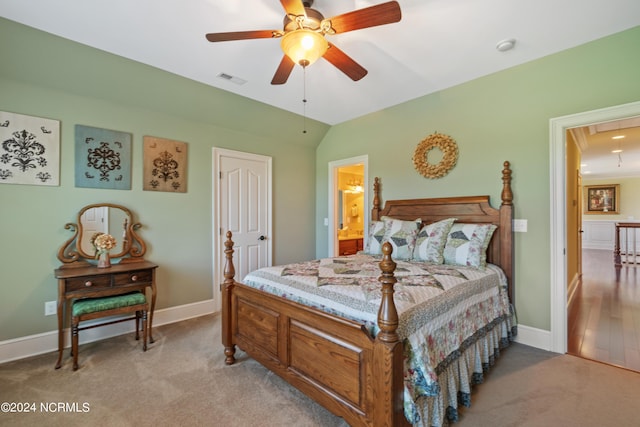 carpeted bedroom with lofted ceiling, visible vents, baseboards, ensuite bath, and attic access