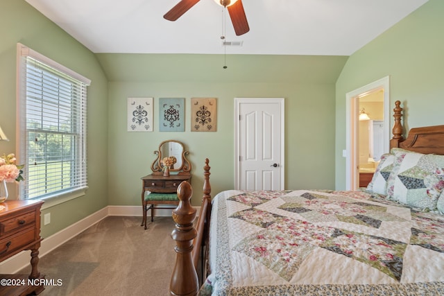 carpeted bedroom with multiple windows, ensuite bathroom, ceiling fan, and lofted ceiling