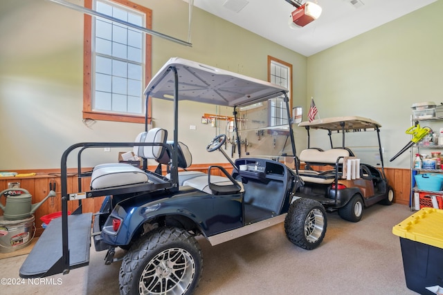 garage featuring a garage door opener and wooden walls