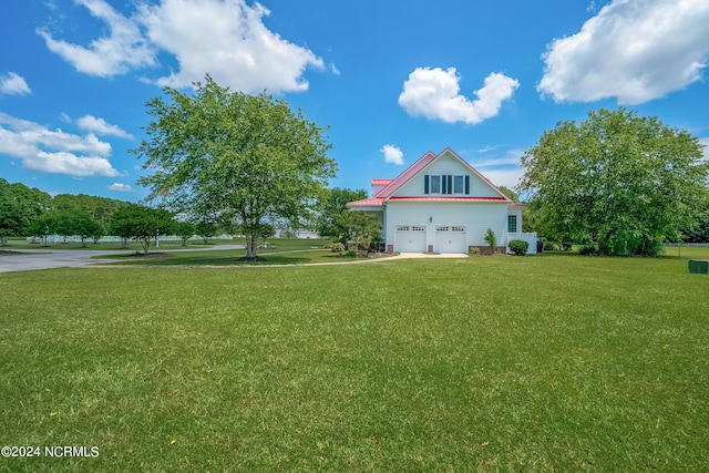 view of side of property featuring a yard and a garage