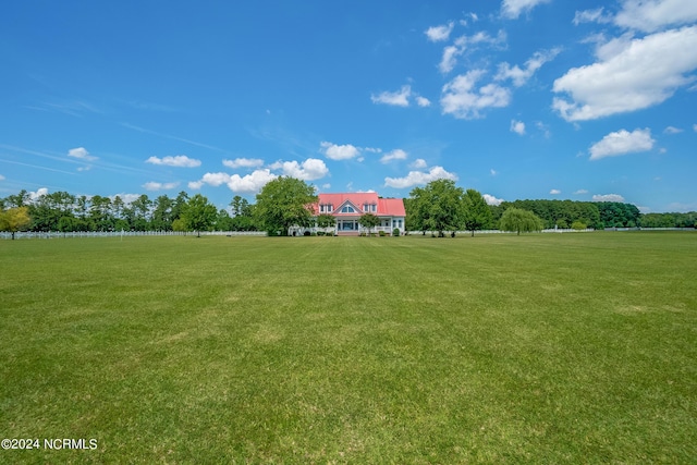 view of home's community with a rural view and a lawn