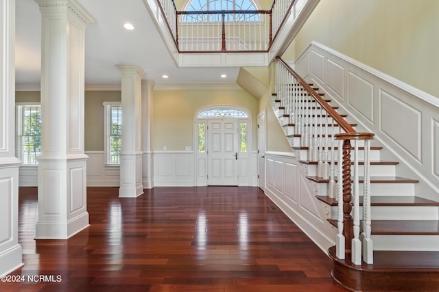 foyer entrance featuring a decorative wall, recessed lighting, ornamental molding, hardwood / wood-style floors, and decorative columns