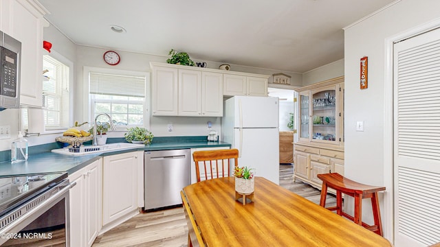 kitchen featuring sink, appliances with stainless steel finishes, light wood-type flooring, and white cabinets